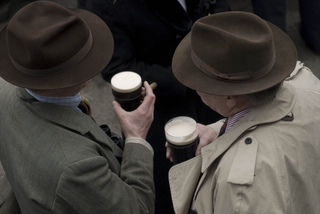 Two men in hats with guiness and cigar seen from above