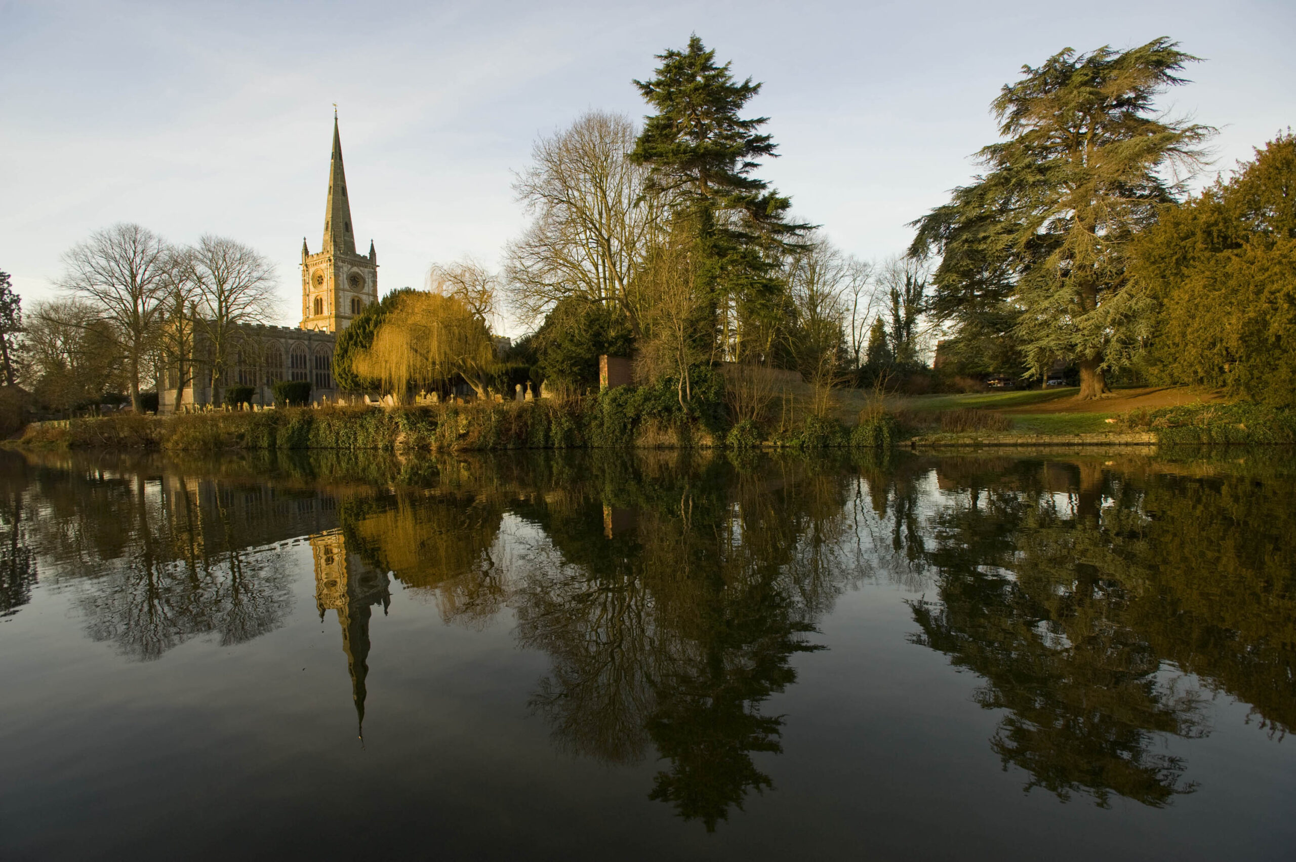 Autumn coloured image across river looking at the Church. landscape in water reflected