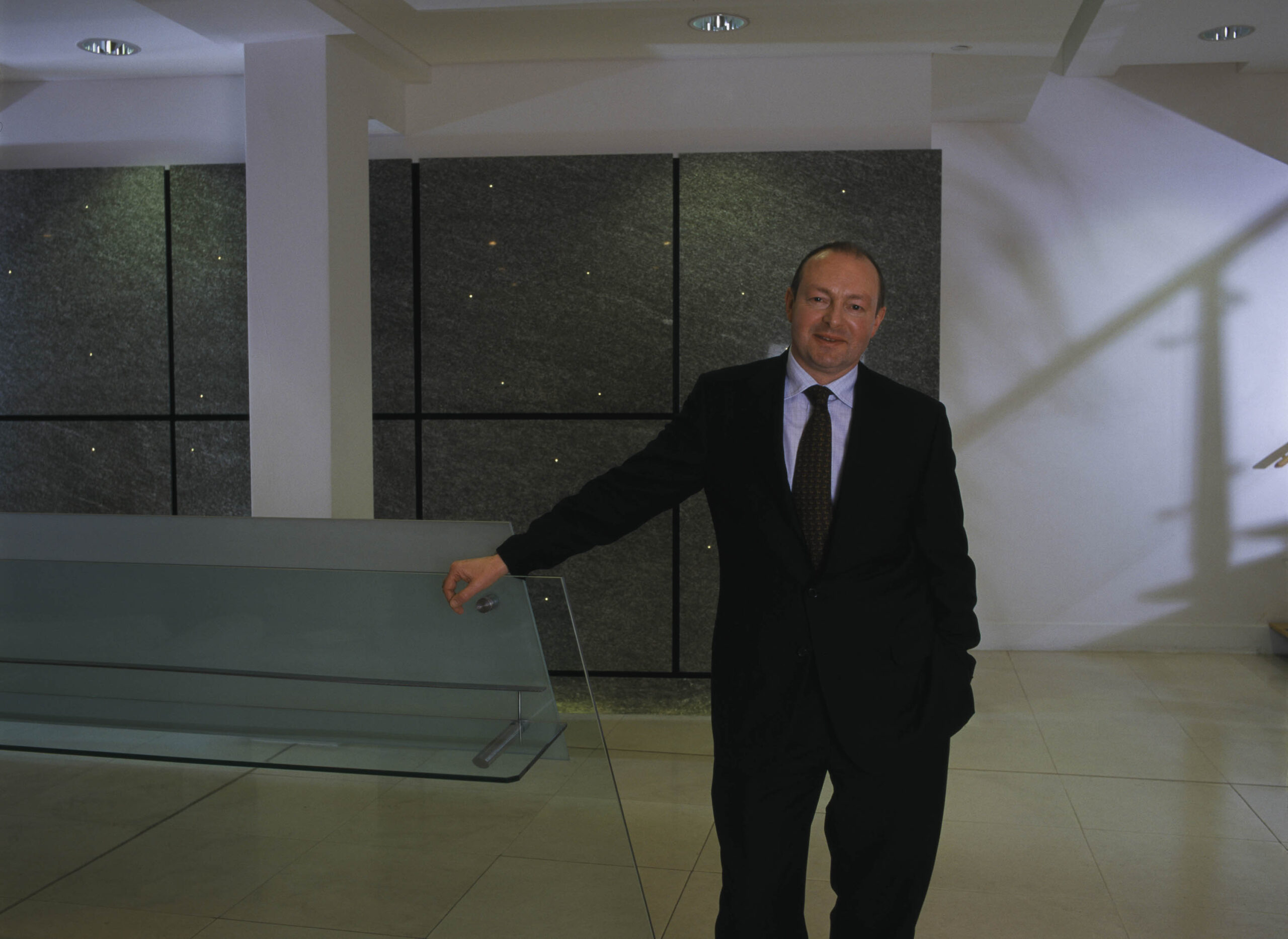 Man in office atrium looking to camera