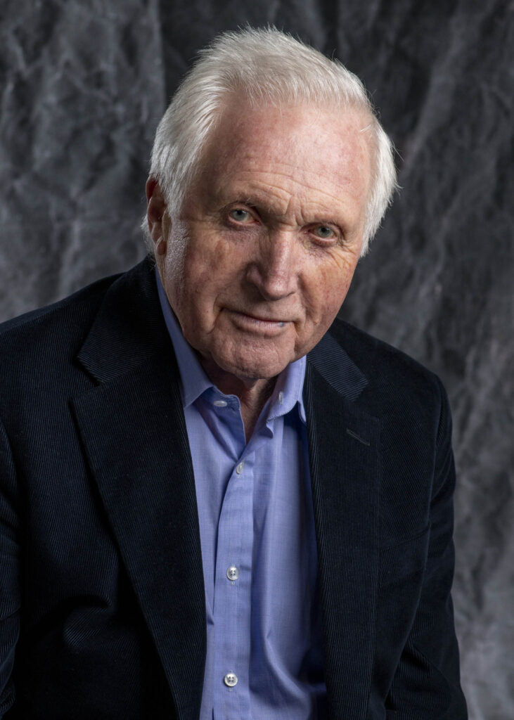 David Dimbleby - headshot with canvas backdrop looking at camera