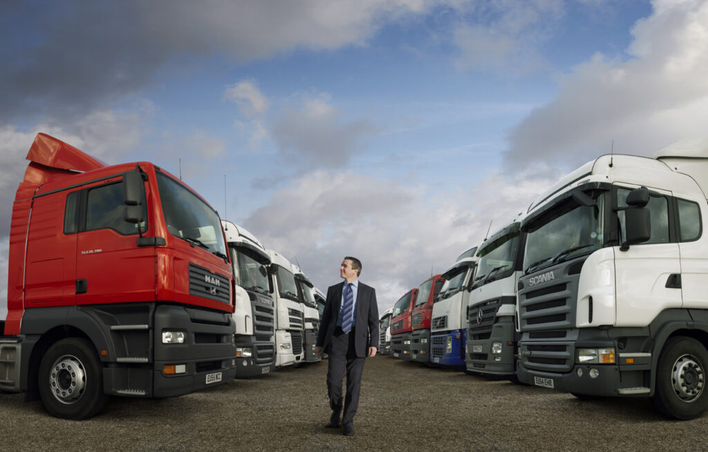 man walking between row of trucks