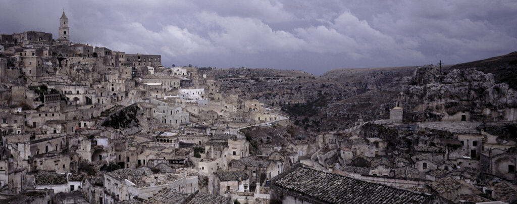 Cityscape with ancient buildings, including many built into the mountain side -