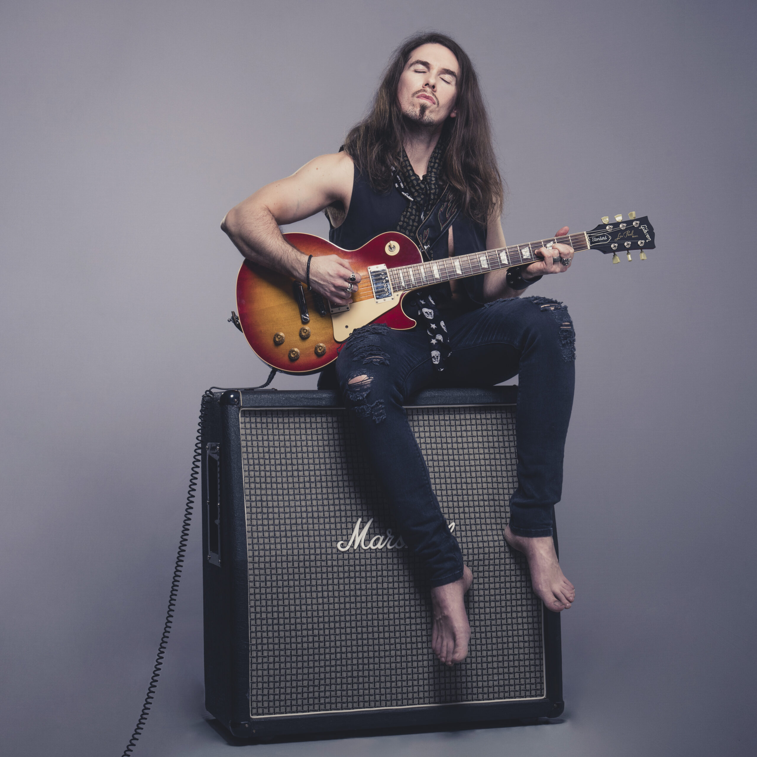 Rock star with Guitar on large amplifer