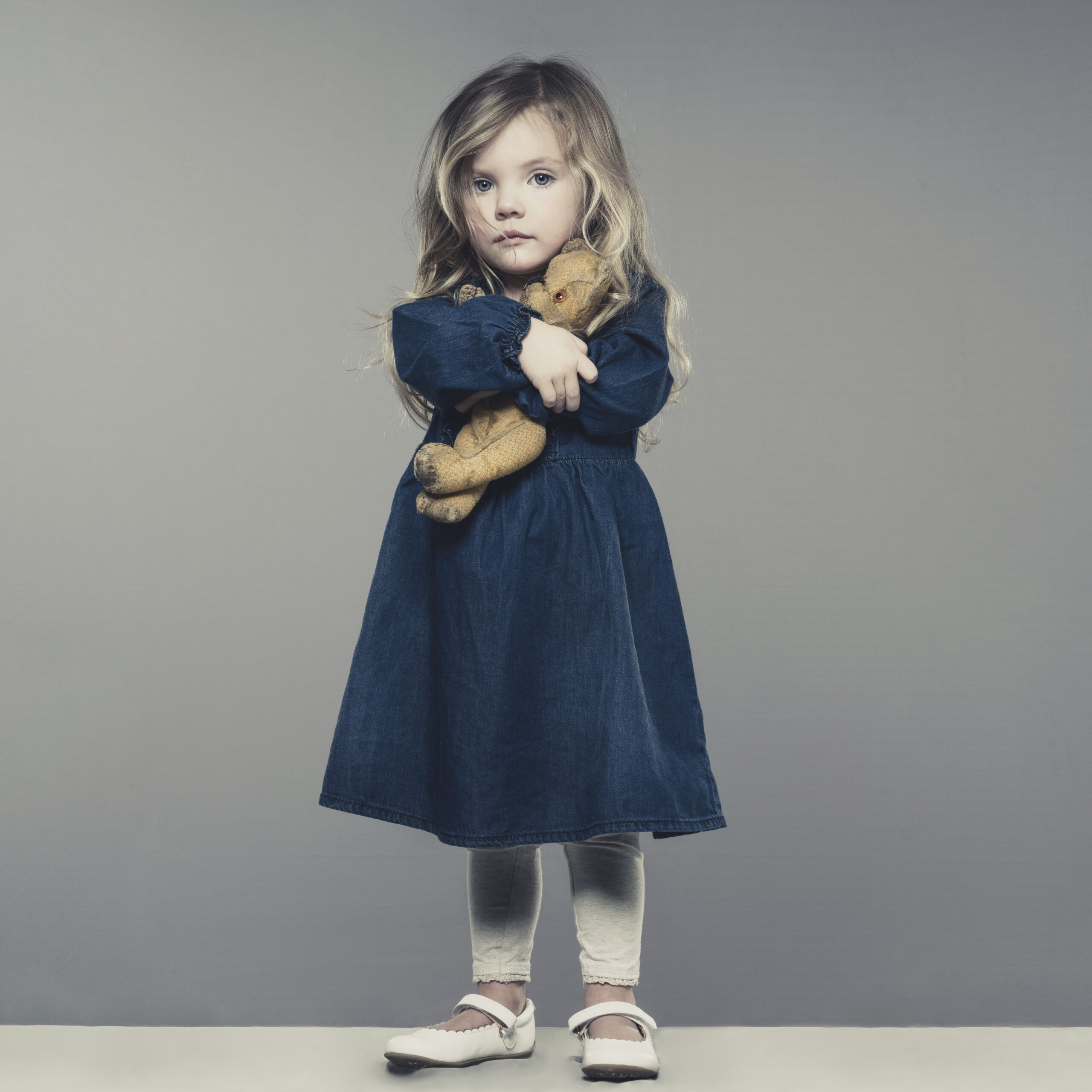 little sad girl with teddy bear