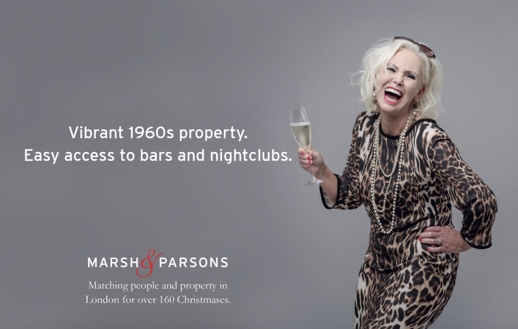 mature lady in party clothes, with glass of fizz having a great time-