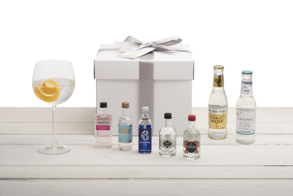 Gin and gift box still life on whaite surface