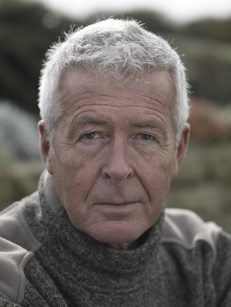 Man with grey hair looking into the camera. Photograph by Gullachsen.