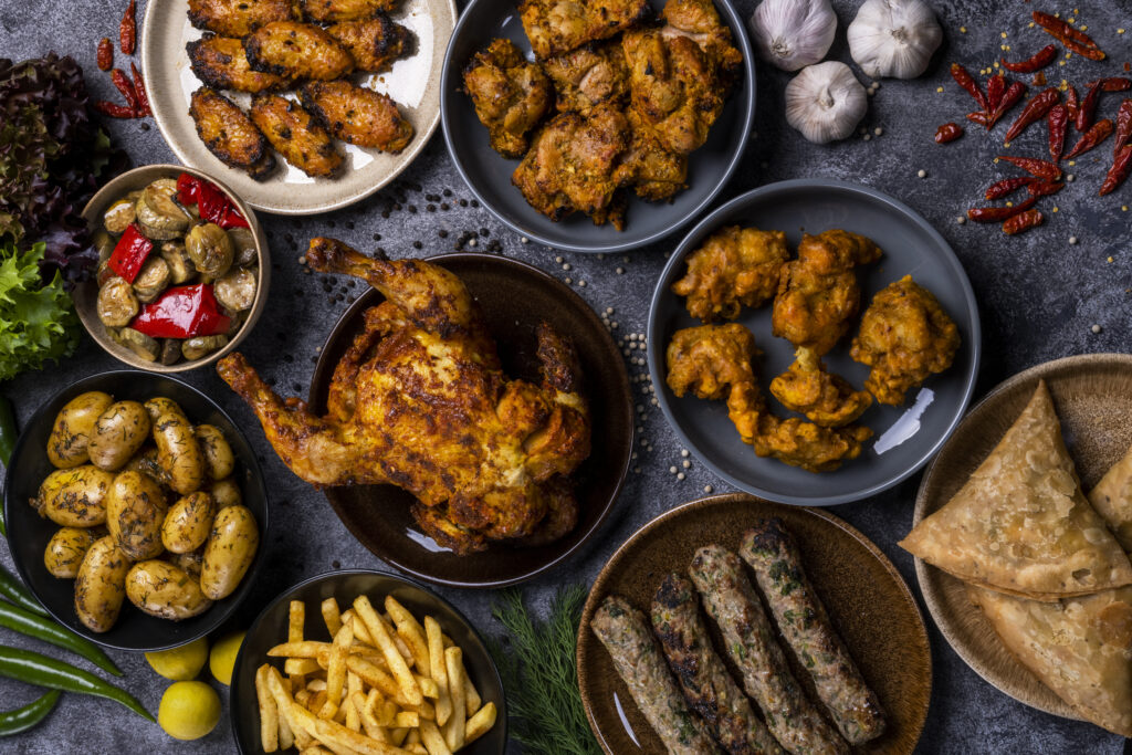 Grilled chicken and indian foods on background