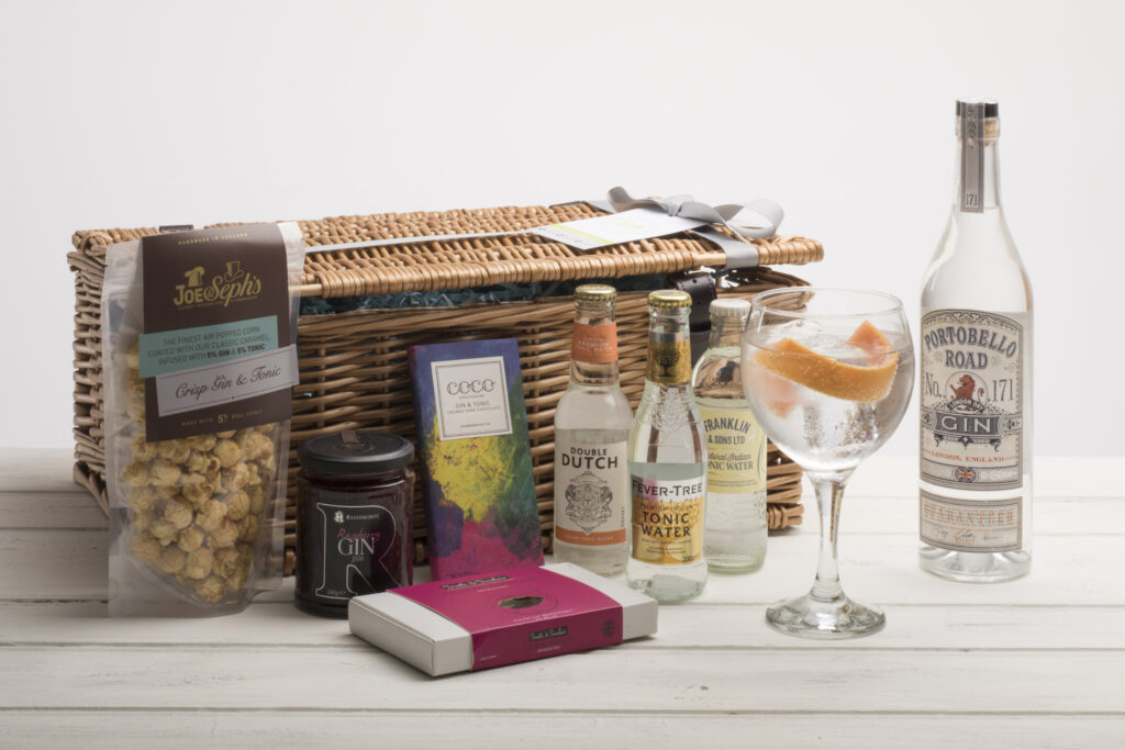 Basket hamper, with contents of Gin and mixers, chocolate with glass of Gin & Tonic with orange twist