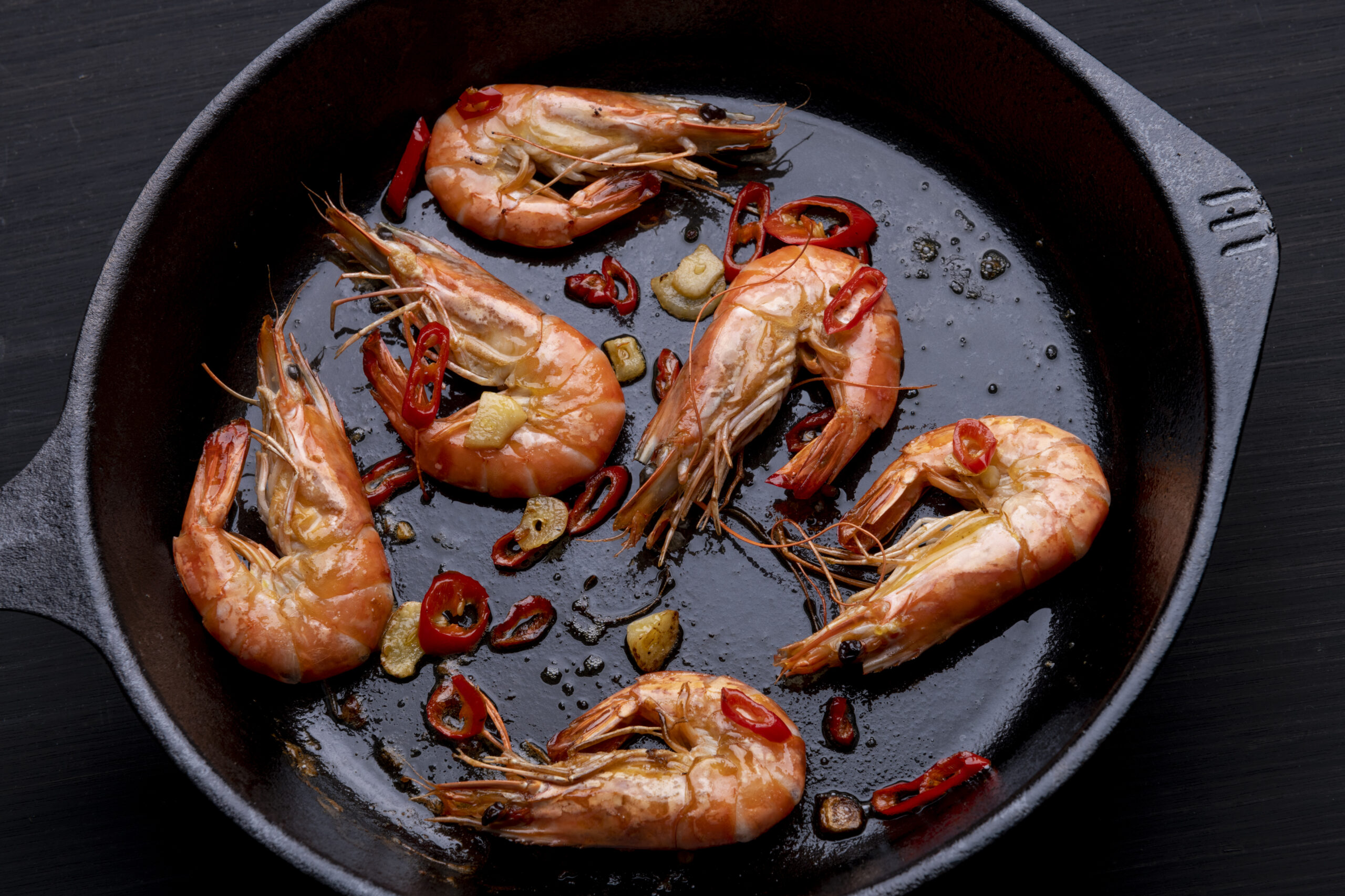 large prawns in cast iron skillet with chilli and garlic