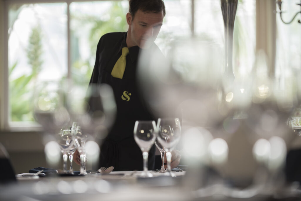 man arranging tableware in soft focus