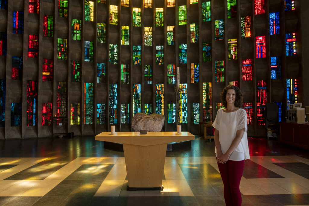 Lady in front of Stained glass windows in Coventry Cathedral
