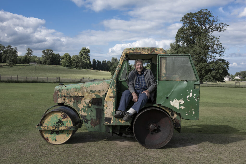 man in grass Roller on cricket pitch