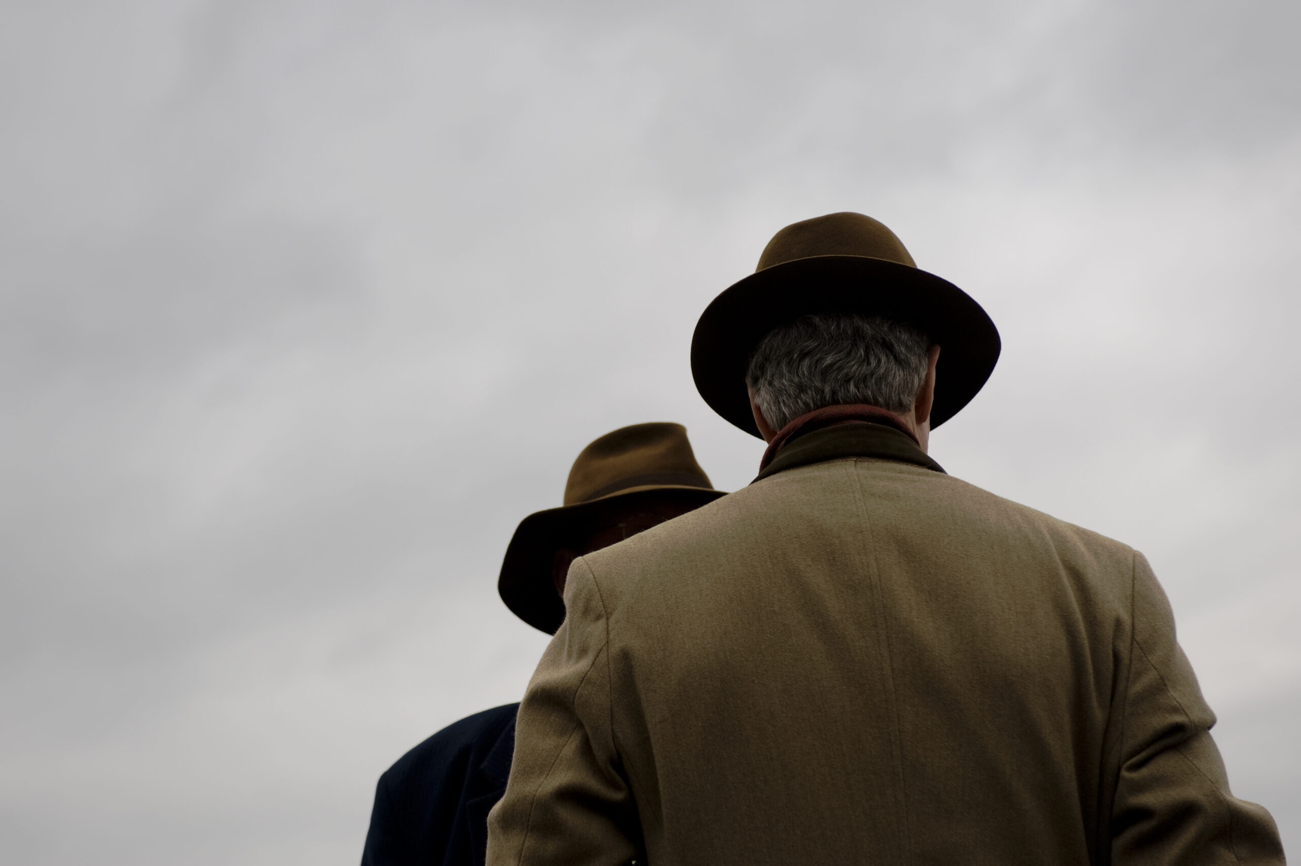 gentlemen in trilby hats against grey cloud, no face detail
