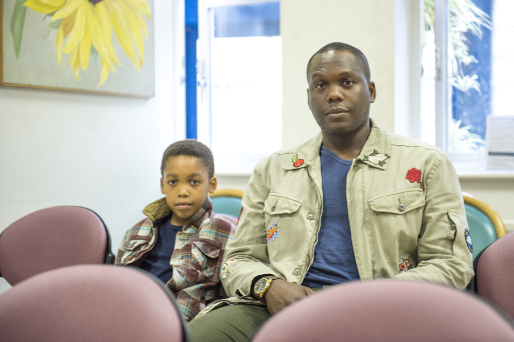 Father and son in waiting room looking concerned