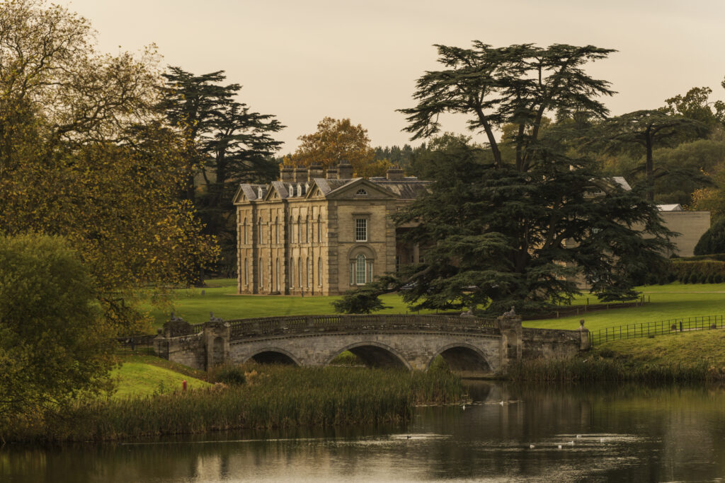Compton Verney house with lake and bridge in warm morning light