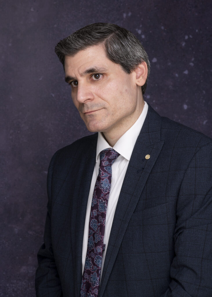 man stares into space, in suit and tie