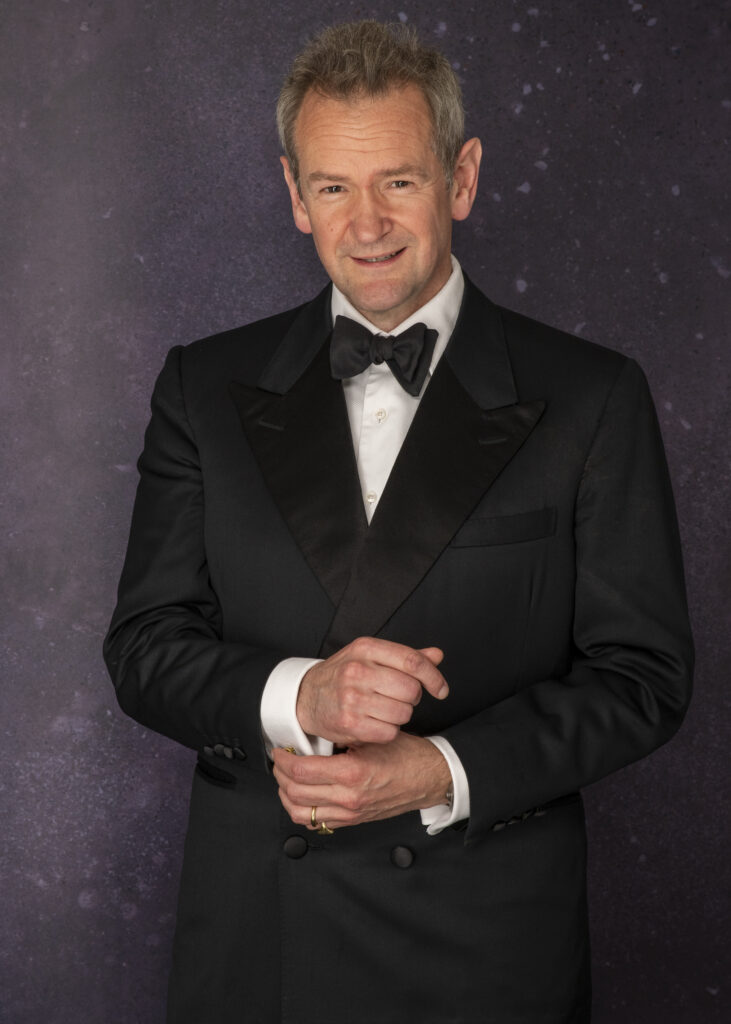 Alexander Armstrong in black tie and suit to camera