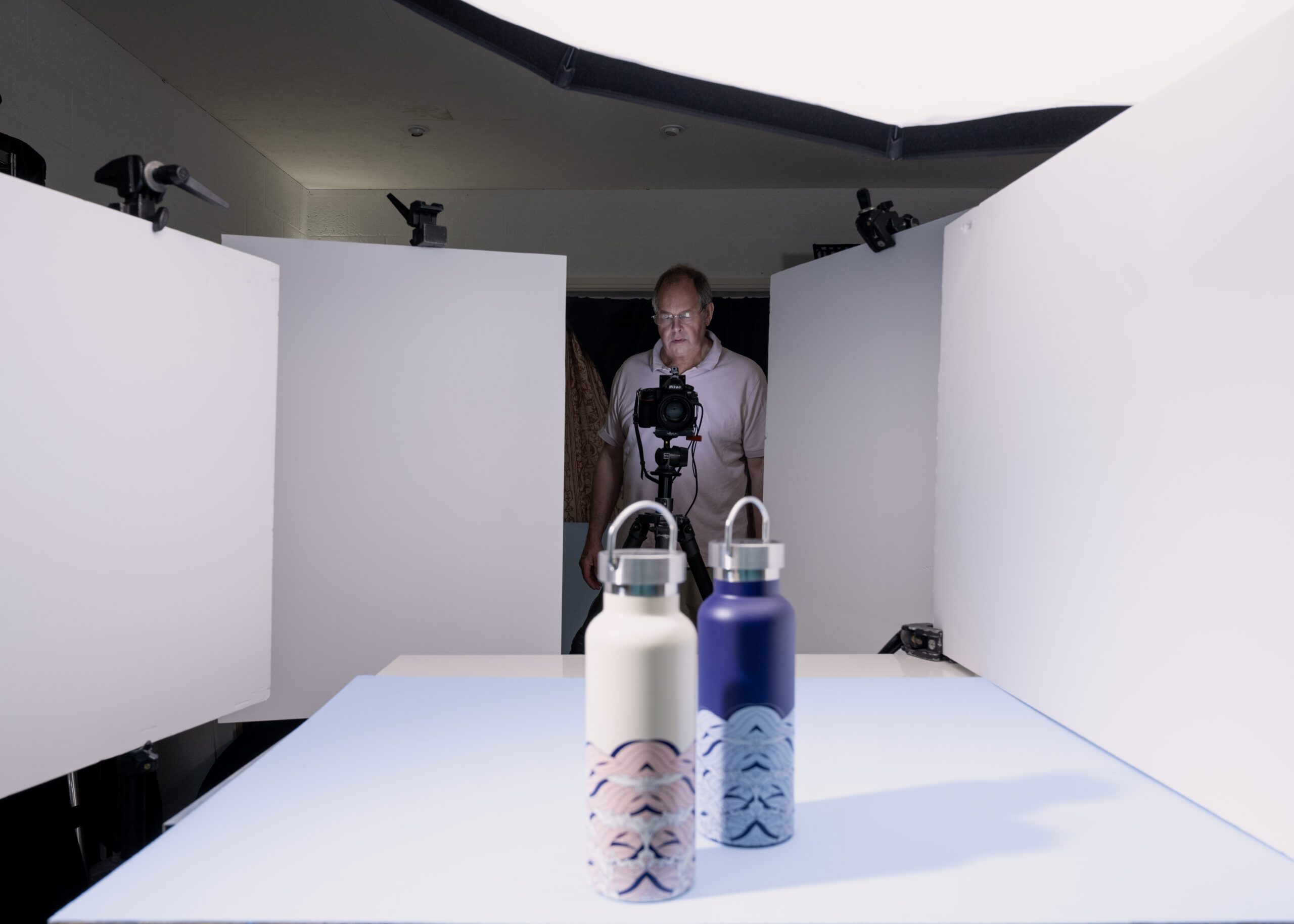 photographer behind camera shooting water containers in a still life